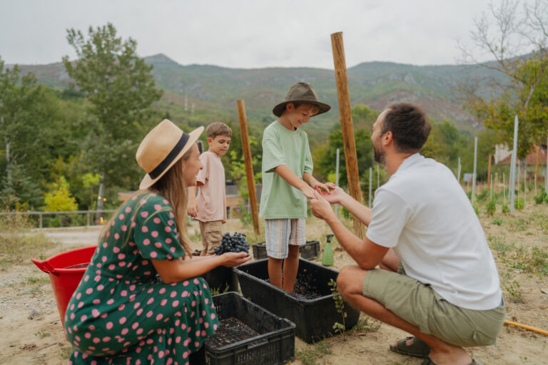 Family in a vineyard enjoying a lifestyle of living off the land, embracing self-sufficiency beyond the 9-5.